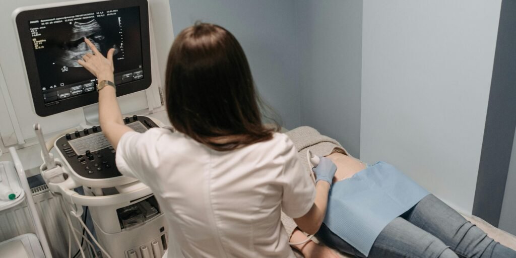 Female doctor conducting an ultrasound screening on a patient in a medical office.