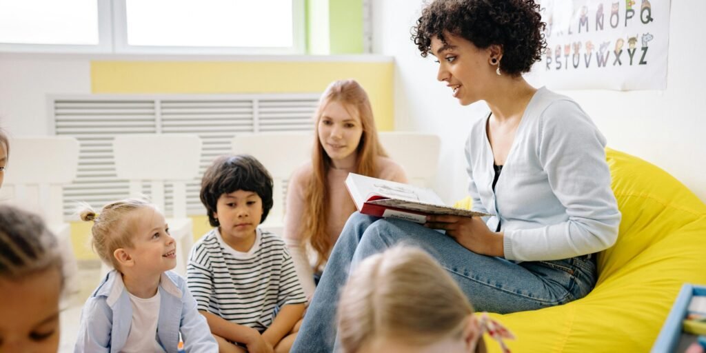 Teacher reading to preschool kids in a colorful classroom setting.